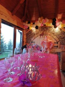 una mesa con mantel rosa con copas de vino y globos en "Carpe diem", en Vlašić