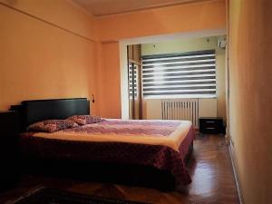 um quarto com uma cama e uma janela com uma cortina em Spacious and Cozy em Tashkent