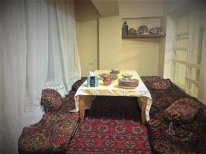 um quarto com uma mesa e cadeiras e uma janela em Spacious and Cozy em Tashkent