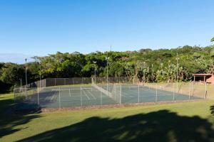 a tennis court with a net in a field at Villa 2527 San Lameer in Southbroom