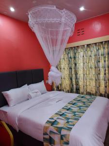 een slaapkamer met een groot bed en een gordijn bij Eldopalm Guesthouse in Eldoret