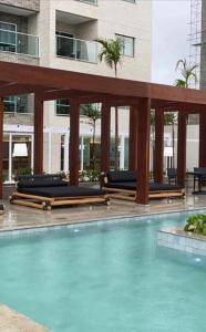una piscina con sedie a sdraio in un edificio di Salinas Exclusive Resort 2 Quartos a Salinópolis