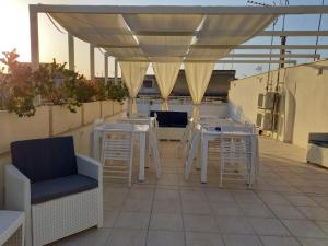 een patio met tafels en stoelen op een dak bij B&B LA GRAZIA in Trani