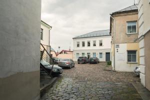 un grupo de autos estacionados en un estacionamiento en Laurentroom Townhouse en Ukmergė