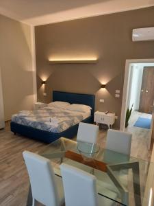 a bedroom with a bed and a glass table and chairs at TRANI LA GRAZIA b&b in Trani