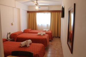 um quarto de hotel com quatro camas e uma janela em Nuevo Hotel Roble em Termas de Rio Hondo