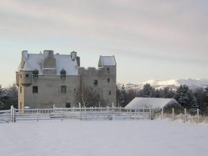 um velho castelo com uma cerca na neve em Faside Estate em Musselburgh