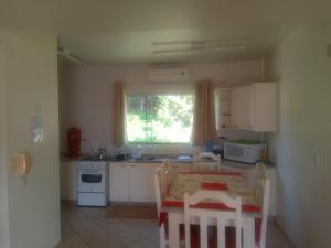 cocina con mesa, sillas y ventana en Apartamento em Marcelino Ramos ao lado das Termas, en Belém Velho
