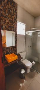 La salle de bains est pourvue de toilettes, d'un lavabo et d'une douche. dans l'établissement Pousada Pato Mergulhão, à Vargem Bonita