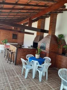eine Terrasse mit einem blauen Tisch und weißen Stühlen in der Unterkunft casa de praia Itaúna saquarema in Saquarema