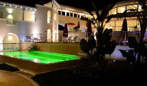 a pool with green illumination in front of a building at Ganimede Hotel in Sperlonga