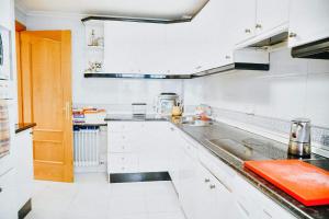 una cucina con mobili bianchi e un lavandino di Apartamentos GARDEN a Salamanca