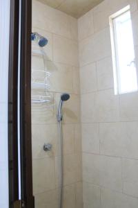 y baño con ducha con cabezal de ducha. en Linda casa tipo loft, con estacionamiento privado., en Tulancingo