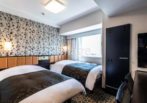 Postel nebo postele na pokoji v ubytování APA Hotel & Resort Niigata Ekimae Odori