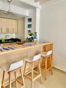 a kitchen with a counter with four chairs and a counter top at Apartamento Edificio Bahia Fragata in San Andrés