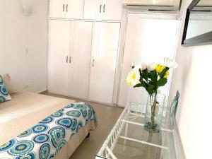 1 dormitorio con un jarrón de flores sobre una mesa de cristal en Apartamento Edificio Bahia Fragata en San Andrés