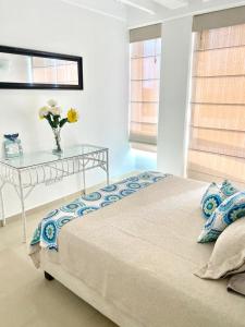 ein Schlafzimmer mit einem Bett und einem Tisch mit einer Blumenvase in der Unterkunft Apartamento Edificio Bahia Fragata in San Andrés