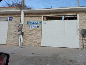 um edifício com uma porta de garagem branca ao lado dele em Shallow Beach em Búzios