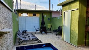 eine Terrasse mit einem Pool und Stühlen sowie ein Gebäude in der Unterkunft Shallow Beach in Búzios