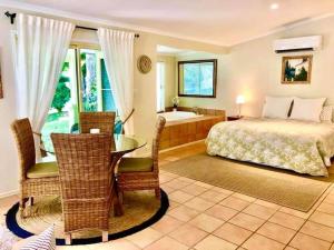 a bedroom with a bed and a table and a tub at Balmoral Cottage in Maleny