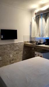 ein Hotelzimmer mit einem Bett und einem Waschbecken in der Unterkunft Shallow Beach in Búzios