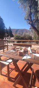 a wooden picnic table with bowls on top of it at Hosteria La Estacion in Tilcara