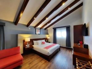 una camera d'albergo con un letto e un divano rosso di Casa San Miguel Hotel Boutique y Spa a Zacatlán