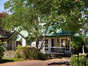 Biały dom z zielonym dachem w obiekcie Lucini Cottage w mieście Hepburn Springs