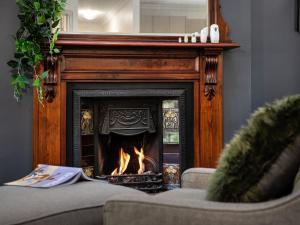a fire in a fireplace in a living room at Lucini Cottage in Hepburn Springs
