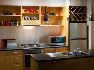 cocina con nevera de acero inoxidable y fregadero en Villa Sorelle en Daylesford
