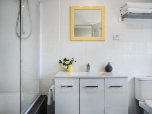 a white bathroom with a sink and a mirror at The Blue Barn in Daylesford