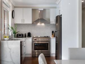 a kitchen with white cabinets and a stainless steel oven at Musk Vale Villa in Musk Vale