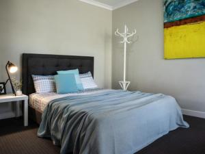 - une chambre avec un grand lit et des oreillers bleus dans l'établissement Musk Vale Villa, à Musk Vale