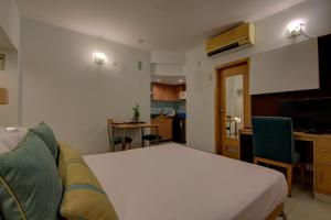 a room with a bed and a couch and a kitchen at Tristar Serviced Apartments in Bangalore