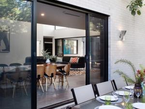 a dining room and living room with sliding glass doors at Arenas South- 3 bedroom, 2 bathroom home in Daylesford