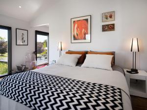 a bedroom with a large bed and two windows at Reverie 101 in Lyonville