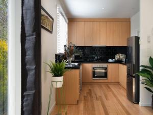 a kitchen with wooden cabinets and a refrigerator at Lake Como Villa in Daylesford