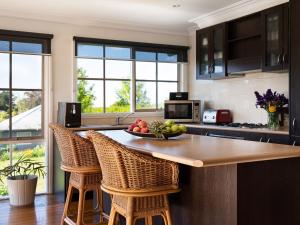 a kitchen with a table with a bowl of fruit on it at Churchills - outstanding views over Daylesford in Daylesford +17 photos