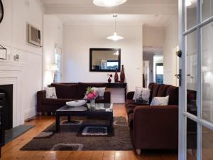 a living room with two couches and a table at Churchills in Daylesford