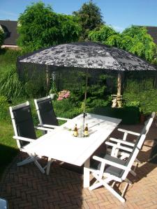 a white table with two chairs and an umbrella at B&B Bru-Beauline in Bruges