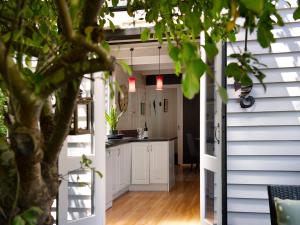 una pequeña casa con cocina abierta y zona de comedor en Viola, en Hepburn Springs
