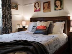 a bedroom with a bed with pillows and pictures on the wall at Viola in Hepburn Springs