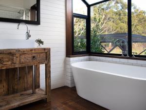 a bath tub in a bathroom with a window at Green Gully House in Glenlyon
