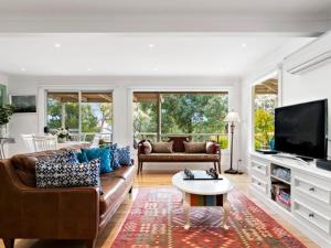 a living room with a couch and a tv at Margies on Mt Franklin 8 minutes from Daylesford in Hepburn Springs