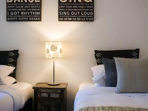 a bedroom with two beds and a table with a lamp at Artemis Retreat in Daylesford