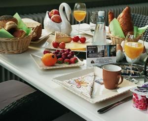 a table with plates of food and glasses of wine at B&B Bru-Beauline in Bruges