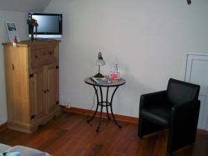 a room with a table and a chair and a television at B&B Bru-Beauline in Bruges