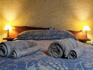 Una cama con tres toallas enrolladas encima. en MI CASA APARTS en Tunuyán