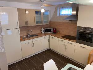 a kitchen with white cabinets and a sink at Apartment Stabel 8,1 km von Europa Park in Kippenheim