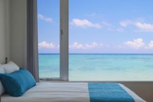 Un dormitorio con una gran ventana del océano en HOTEL MTB, en Motobu